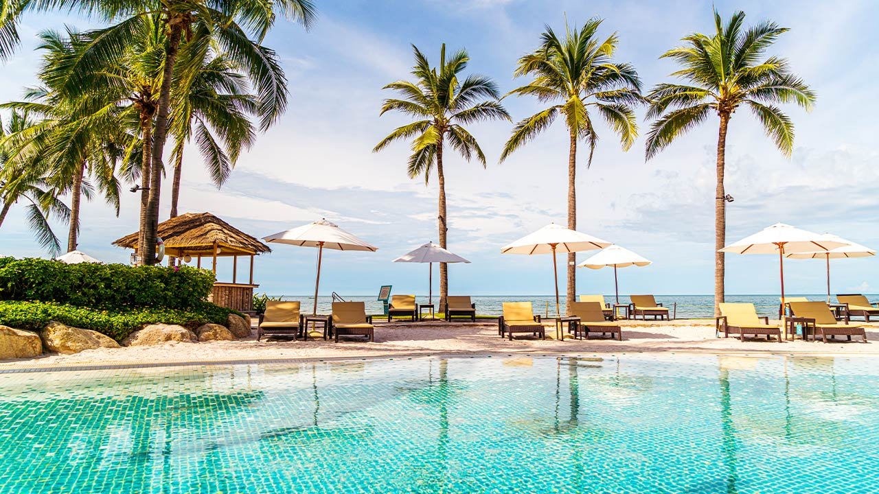 Resort pool lined with palm trees