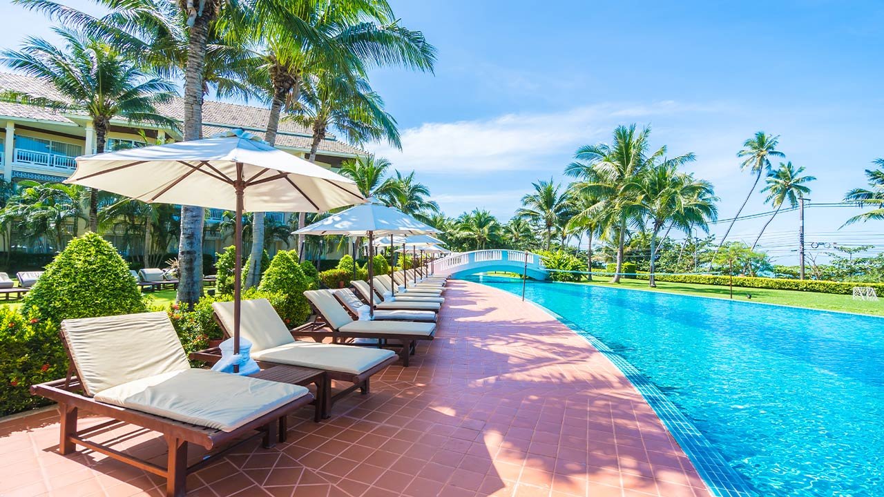 Resort pool with umbrellas and palm trees